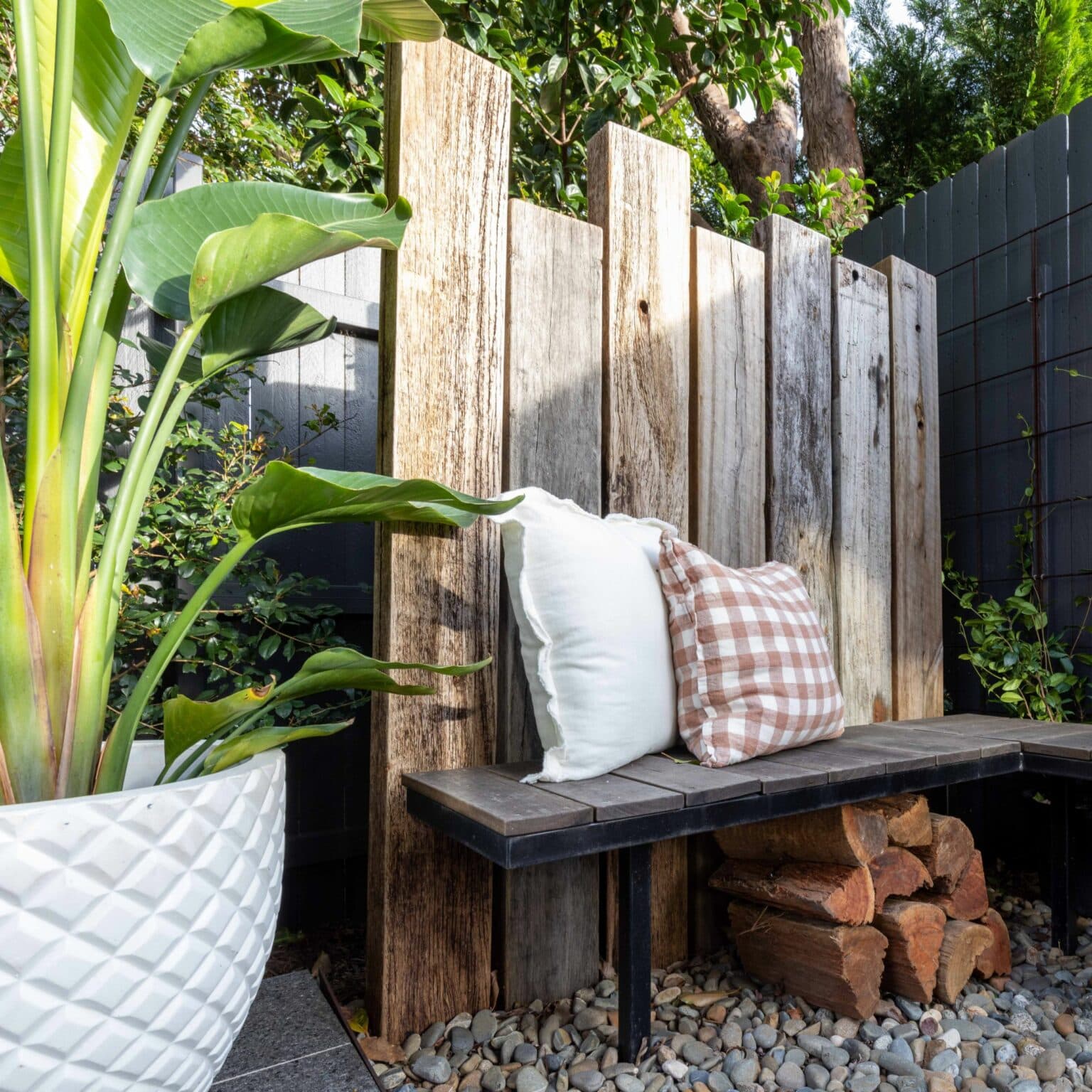 Garden seating area with wooden fence and cushions